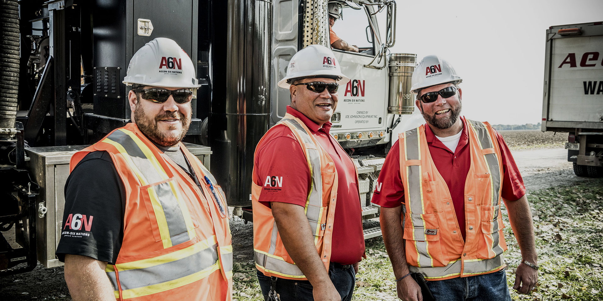 Three men smiling in hardhats