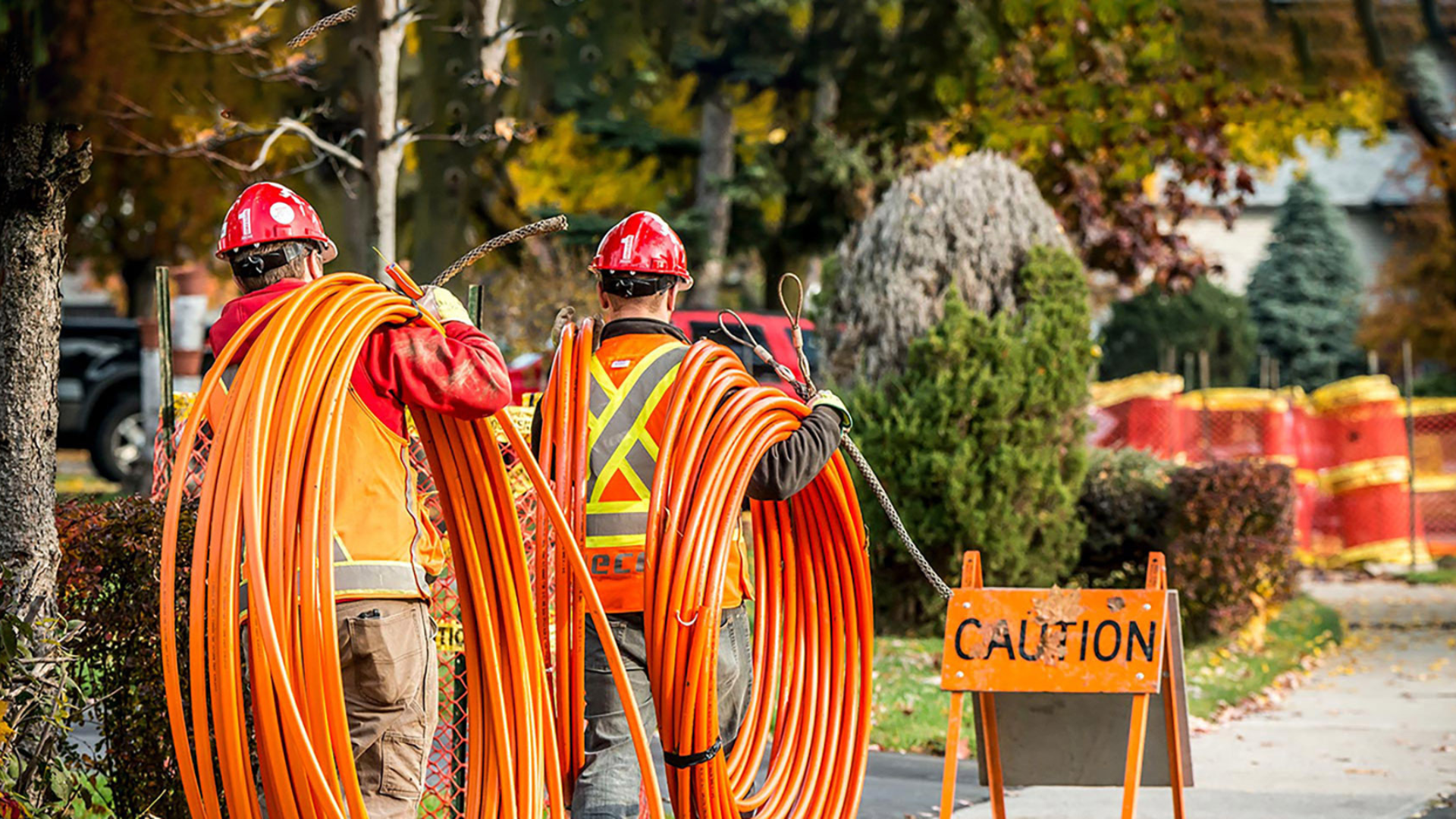 Two men carrying utility wires